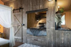 卡斯尔梅恩Castlemaine Gardens Luxury Safari Tents的一间卧室配有一张木墙床