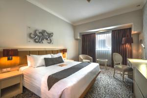 泗水维尔伍德服务公寓及酒店的配有一张床和一张书桌的酒店客房