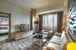 泗水维尔伍德服务公寓及酒店的客厅配有沙发和电视。