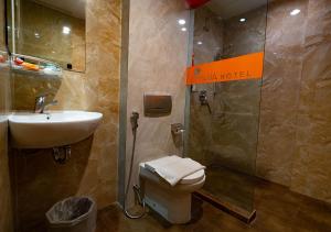 棉兰米亚那酒店的浴室配有卫生间、盥洗盆和淋浴。