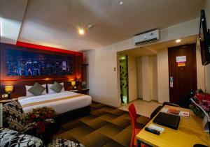棉兰米亚那酒店的配有一张床和一张书桌的酒店客房