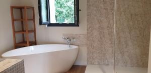 Tournedos-sur-SeineClairseine的带窗户的浴室内的白色浴缸