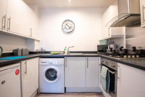 曼斯菲尔德No11 Nursery Covent的厨房配有洗衣机和墙上的时钟