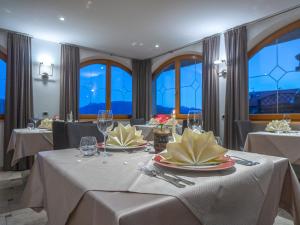 马兰扎奥博勒纳酒店的一间用餐室,配有2张带白色桌布的桌子
