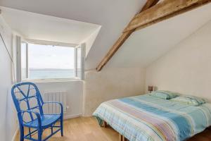 克拉斯卡诺特Villa des Roches - vue mer exceptionnelle的一间卧室配有一张床和一张蓝色椅子