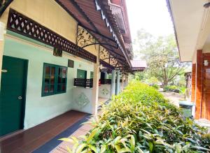 麻坡萨巴克阿沃度假村的一座带绿门和灌木丛的建筑