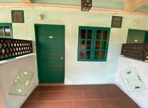 麻坡萨巴克阿沃度假村的两扇绿门,位于一栋带瓷砖地板的建筑内