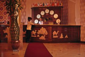 撒马尔罕梅克斯特皇宫酒店的男人和女人站在带钟表的柜台后面