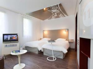 莱斯坎四季里尔机场酒店的酒店客房设有两张床和电视。