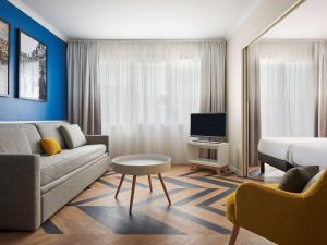 巴黎凡尔赛宫阿德吉奥公寓酒店的客厅配有沙发和1张床