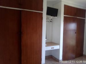 希伯丁Unit 6 Villa Marina的客房设有衣柜、书桌和电视。