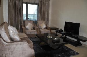 阿吉曼Reef Hotel Aparts (Tabasum Group)的客厅配有两把椅子和电视