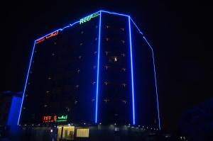 阿吉曼Reef Hotel Aparts (Tabasum Group)的一座晚上有蓝色灯光的建筑