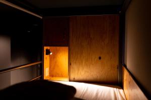 东京Wise Owl Hostels River Tokyo的一间暗室,配有一张木墙床