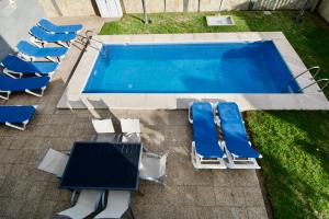 马斯帕洛马斯洛维斯别墅酒店的享有带躺椅和桌子的游泳池以及游泳池的顶部景致。