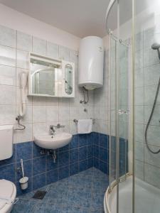 卡尼卡Apartments Hostin Roža Duga Uvala的一间带水槽和玻璃淋浴的浴室