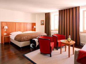 卢塞恩皮拉图库姆酒店的酒店客房带一张床、一张桌子和椅子