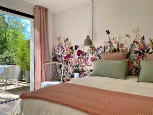 阿尔比Chambres avec Jacuzzi privatif - Kassiopée Bed & Spa的一间卧室设有一张床和花墙