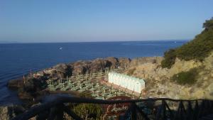 塔拉莫内Casa vacanze mare blu的靠近海洋的悬崖上的一组容器