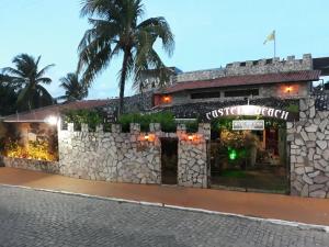 纳塔尔海滩城堡酒店的一座拥有石墙和棕榈树的建筑