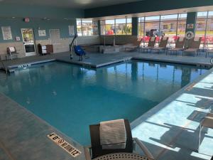 米德尔顿Holiday Inn Express & Suites - Madison West - Middleton, an IHG Hotel的大楼内带椅子的大型游泳池