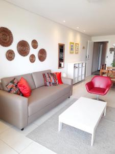 阿奎拉兹Mandara Lanai Porto das Dunas的带沙发和红色椅子的客厅