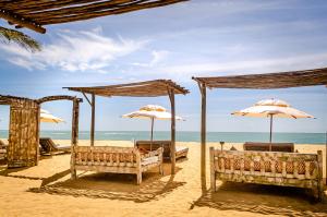 托兰克索Villas de Gaia Hotel Boutique的沙滩上带遮阳伞和椅子的海滩