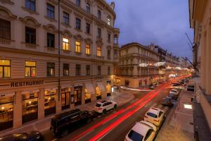 布拉格Unesco Prague Apartments的街道上,夜间有车辆停放的城市街道
