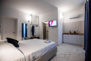 锡拉库扎Domus Vittoria Siracusa的一间卧室配有一张床,墙上配有电视