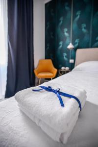 锡拉库扎Domus Vittoria Siracusa的床上的白色毛巾和蓝色的带子