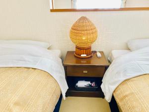 白马村仁格特别墅酒店的两床之间的床头柜上的一盏灯