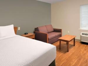克拉克斯维尔克拉克斯维尔伍德斯普林路易斯维尔酒店的配有一张床和一把椅子的酒店客房