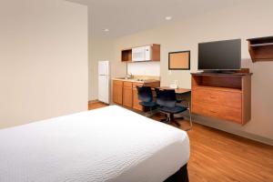 Air Base City霍布斯伍德思普汽车旅馆的一间卧室配有一张床和一张书桌及电视