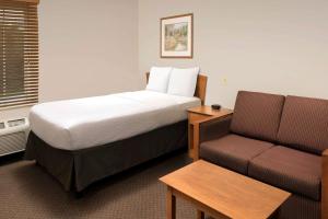 邓肯WoodSpring Suites Spartanburg Duncan的酒店客房,配有床和沙发