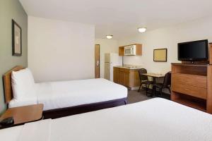里士满WoodSpring Suites Richmond West I-64的酒店客房设有两张床和电视。