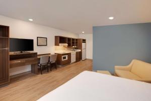 休斯顿WoodSpring Suites Houston Northwest的酒店客房设有厨房和客厅。