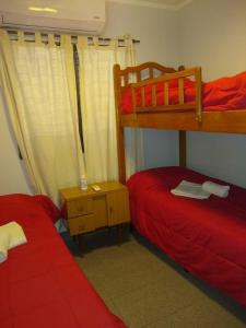 Establecimiento Las CostasCasa de Vacaciones ADELITA的一间卧室配有两张双层床,铺有红色床单
