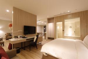 竹北新竹安捷国际酒店的一间卧室配有一张床、一张书桌和一台电视