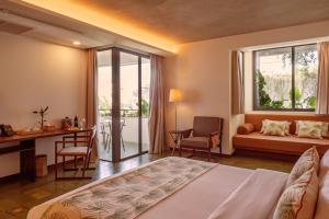金边Penh House Hotel的一间卧室配有一张床、一张书桌和一个窗户。