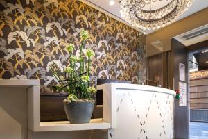 巴黎道努歌剧酒店的墙上装饰有花卉图案的墙纸和植物的房间