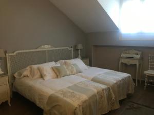 Colmenar del Arroyo阿不思阿尔比乡间农舍的一间卧室配有一张带白色床单的床和一扇窗户。