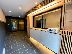 京都HIZ HOTEL Gion-Shirakawa的厨房设有窗户和台面上的微波炉