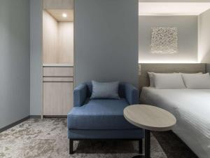 札幌HOTEL FORZA SAPPORO STATION的一间卧室配有一张床和一张蓝色椅子