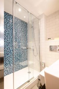 博尔顿假日博尔顿中心酒店的带淋浴的浴室和玻璃门