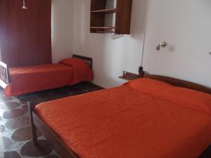 圣格雷戈里奥德波兰科Hotel Buena Vista Se reserva solo con seña的配有橙色床单的客房内的两张床