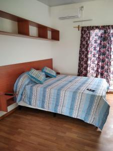 科洛尼亚-德尔萨克拉门托La Comarca的一间卧室配有一张带木制床头板的床和窗户。