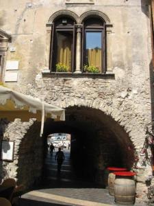 加尔达Palazzo Fregoso的穿过隧道的人,在有窗户的建筑物下