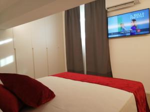 里乔内La Mansardina的卧室配有一张床铺,墙上配有电视