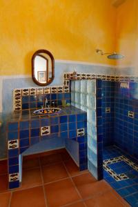 La Ventana温塔娜湾度假酒店的浴室铺有蓝色瓷砖,配有镜子和水槽