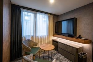 奈良AN-GRANDEホテル奈良的酒店客房配有电视、桌子和椅子。